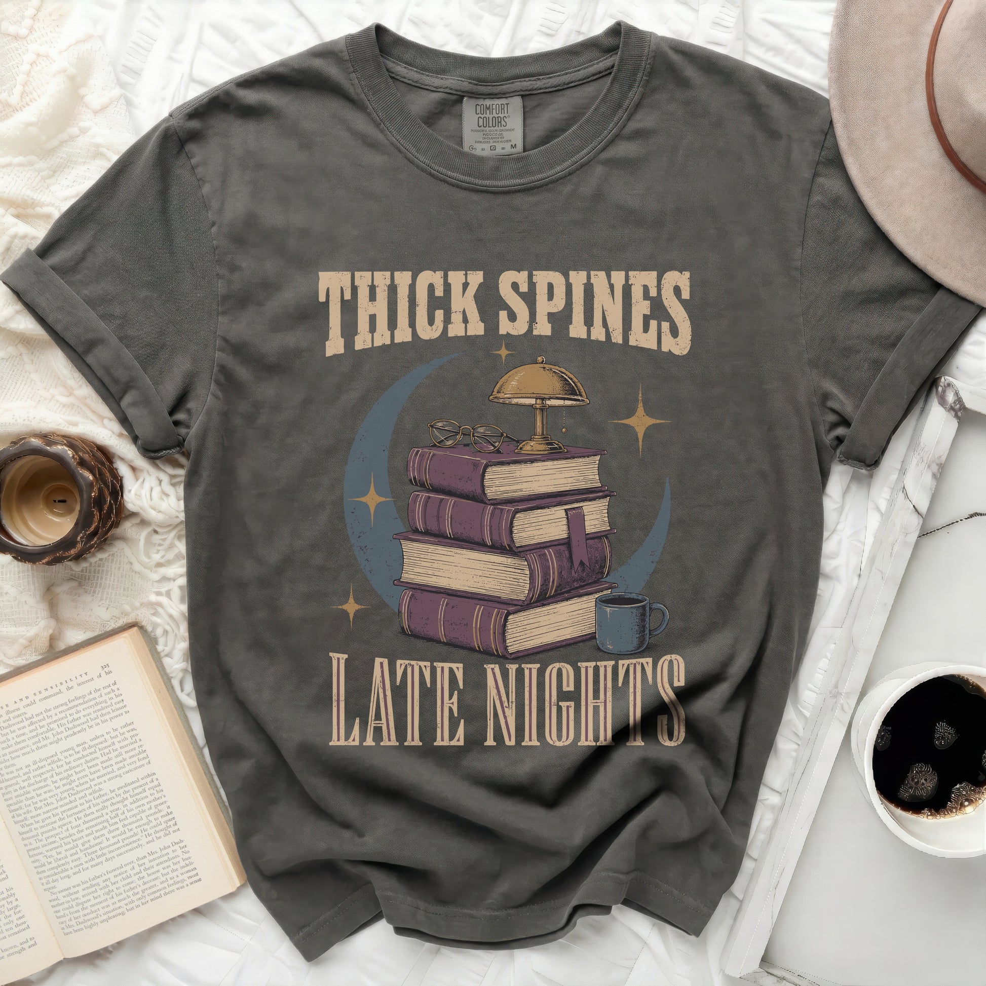 Graphic tee with "Thick Spines Late Nights" and stack of books design.