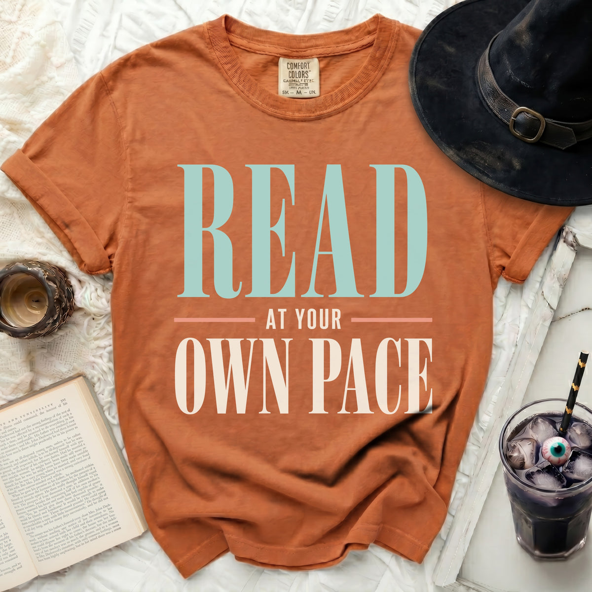 Orange t-shirt with "READ AT YOUR OWN PACE" text.