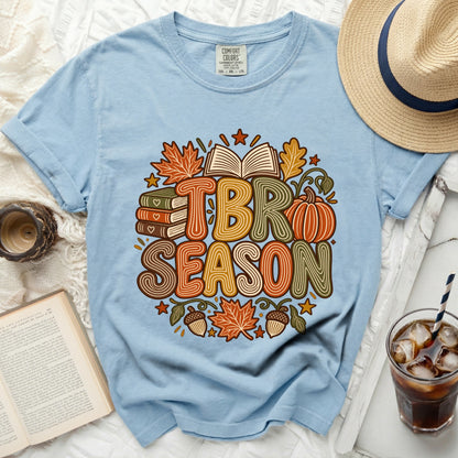 Light blue t-shirt with "TBR Season" in colorful lettering, surrounded by books, a pumpkin, and fall leaves.