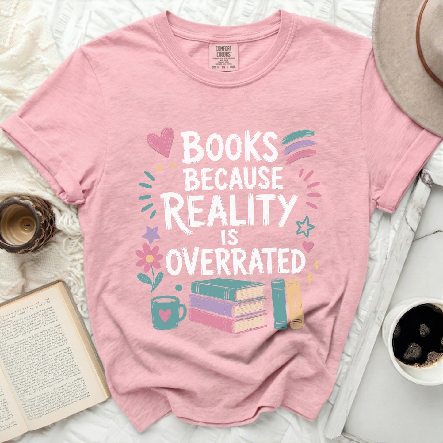 Pink t-shirt with "Books Because Reality Is Overrated" text and illustrations.