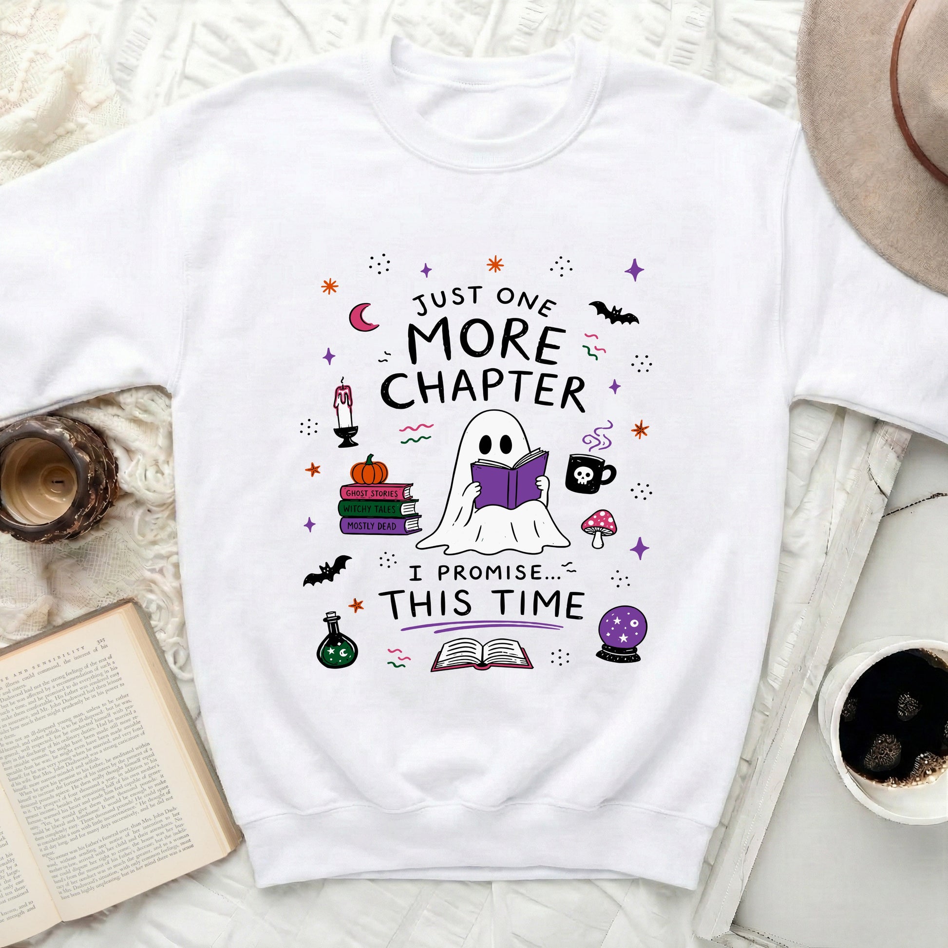 White sweatshirt with ghost reading book. Text: "Just One More Chapter. I Promise... This Time."