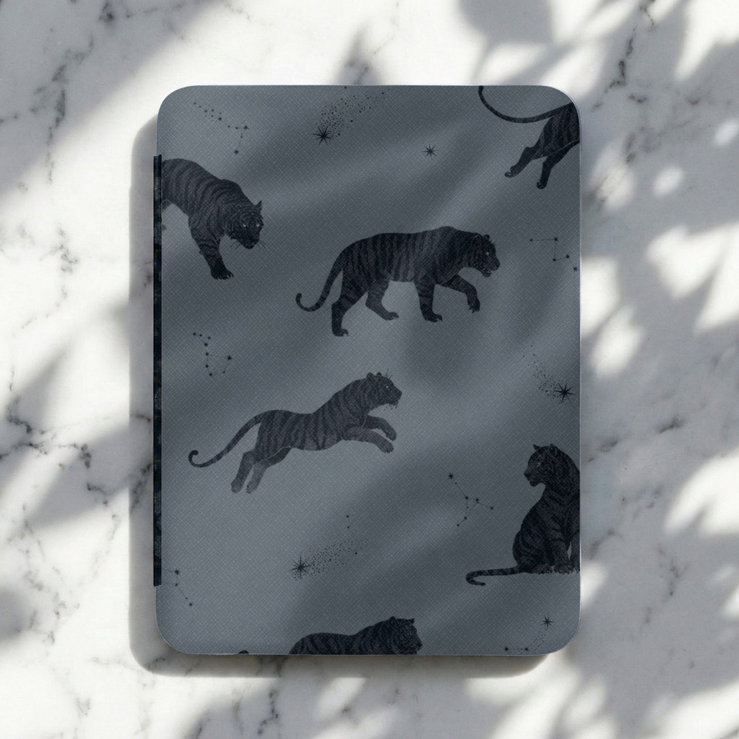Dark gray cover with a repeating pattern of black tigers and constellations.