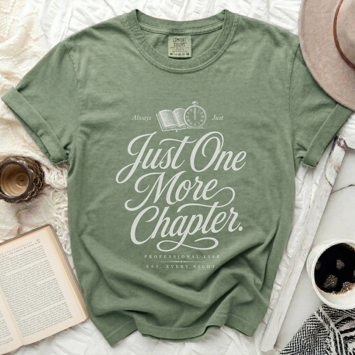 Green t-shirt with "Just One More Chapter" and "Professional Liar" text.