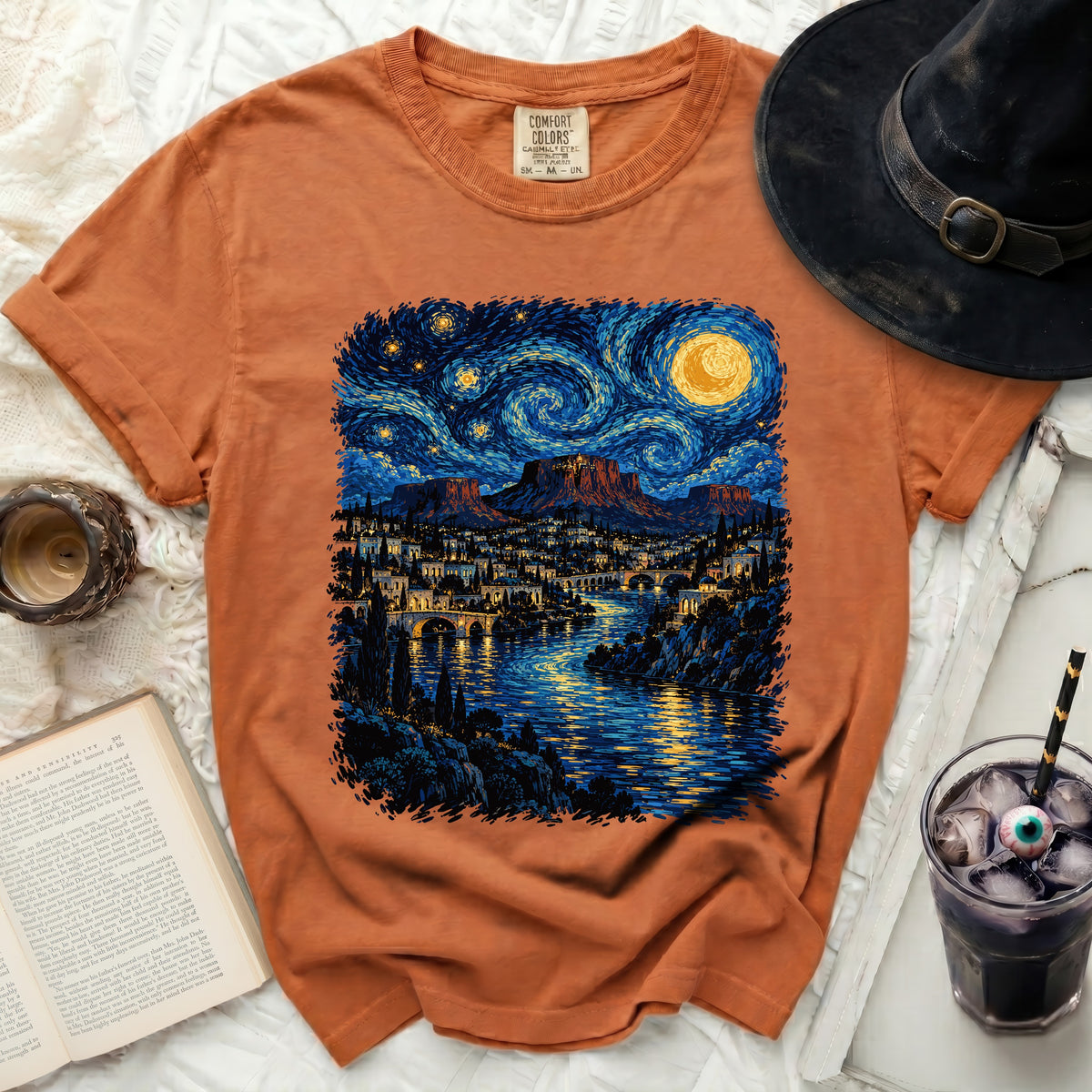Orange t-shirt with starry night landscape print featuring a city and river.