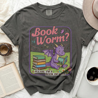 Grey t-shirt featuring a graphic with a purple dragon reading a book, text "Book Worm? Please, I'm a BOOK DRAGON".