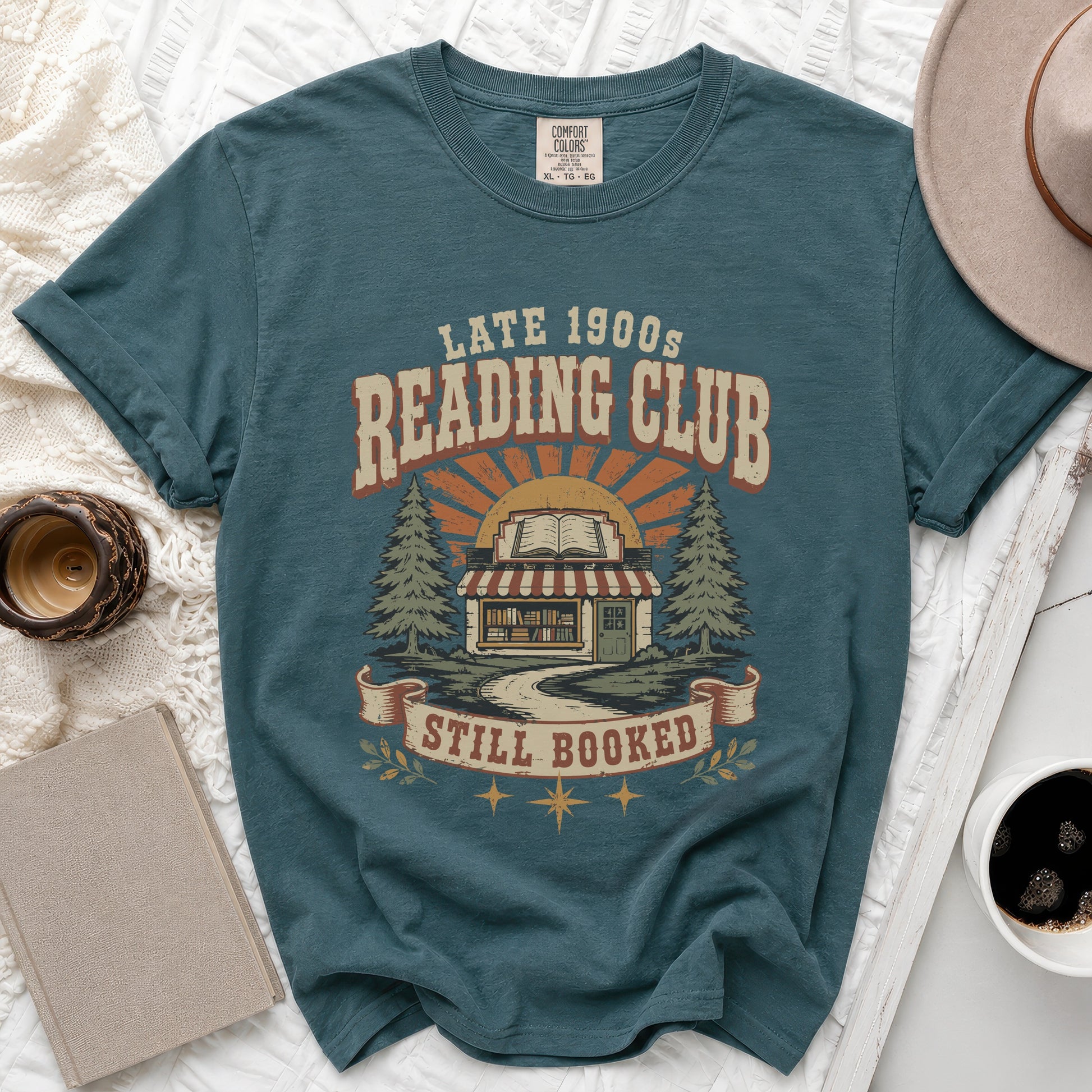 Teal t-shirt with "Late 1900s Reading Club Still Booked" graphic.