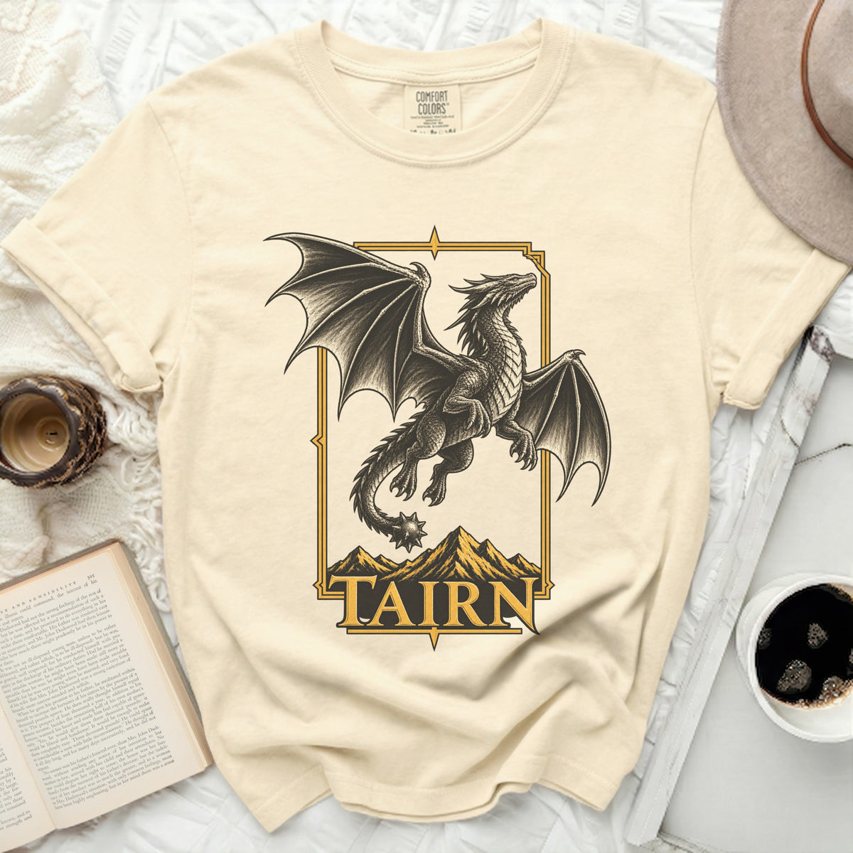Cream t-shirt with a black dragon and mountains graphic, text "TAIRN".