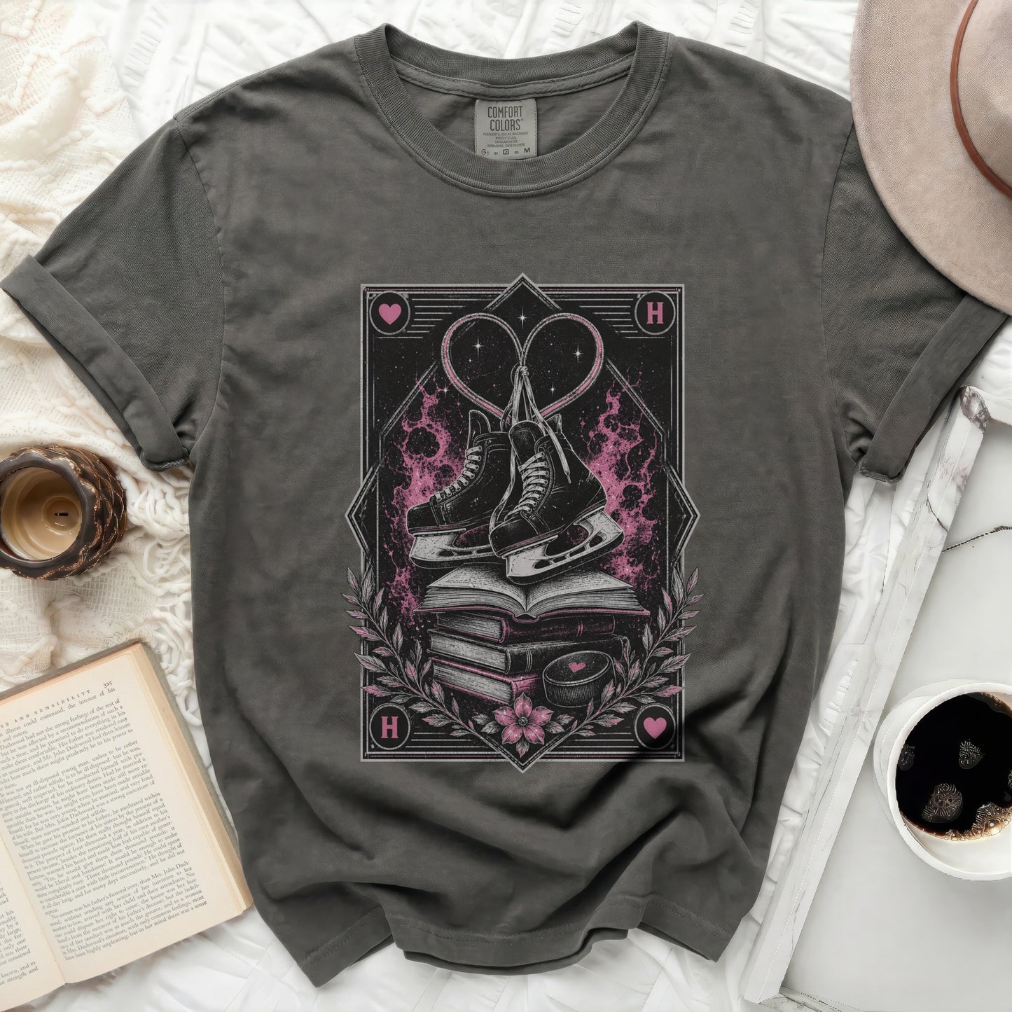Dark t-shirt with stacked books, ice skates, and heart graphic.