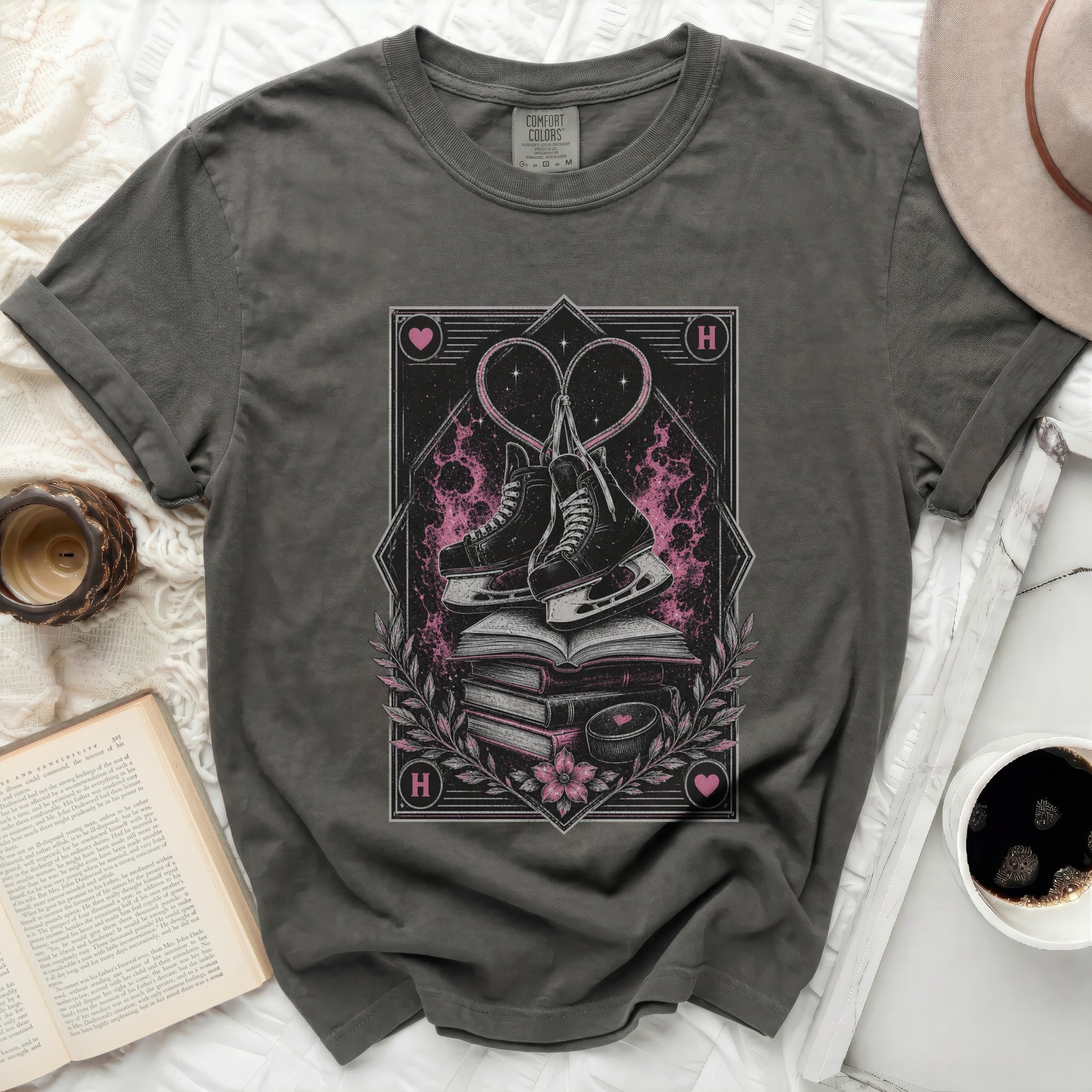 Dark t-shirt with stacked books, ice skates, and heart graphic.