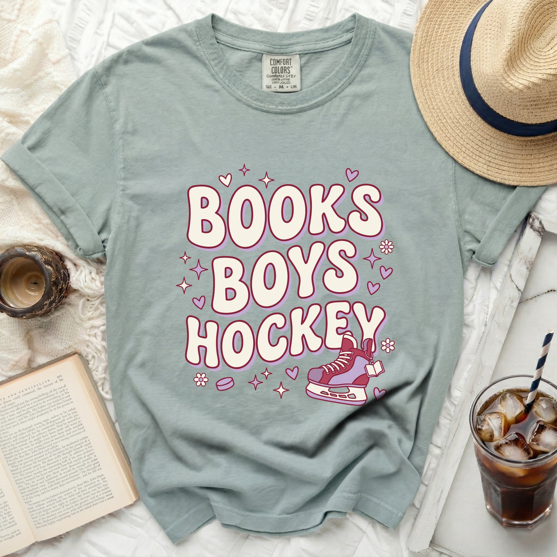 "Books Boys Hockey" text with heart and flower graphics on a mint green t-shirt.