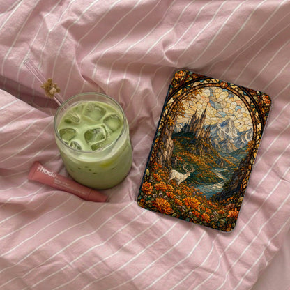 Phone case with stained glass castle, mountains, deer, and flowers on pink striped fabric.