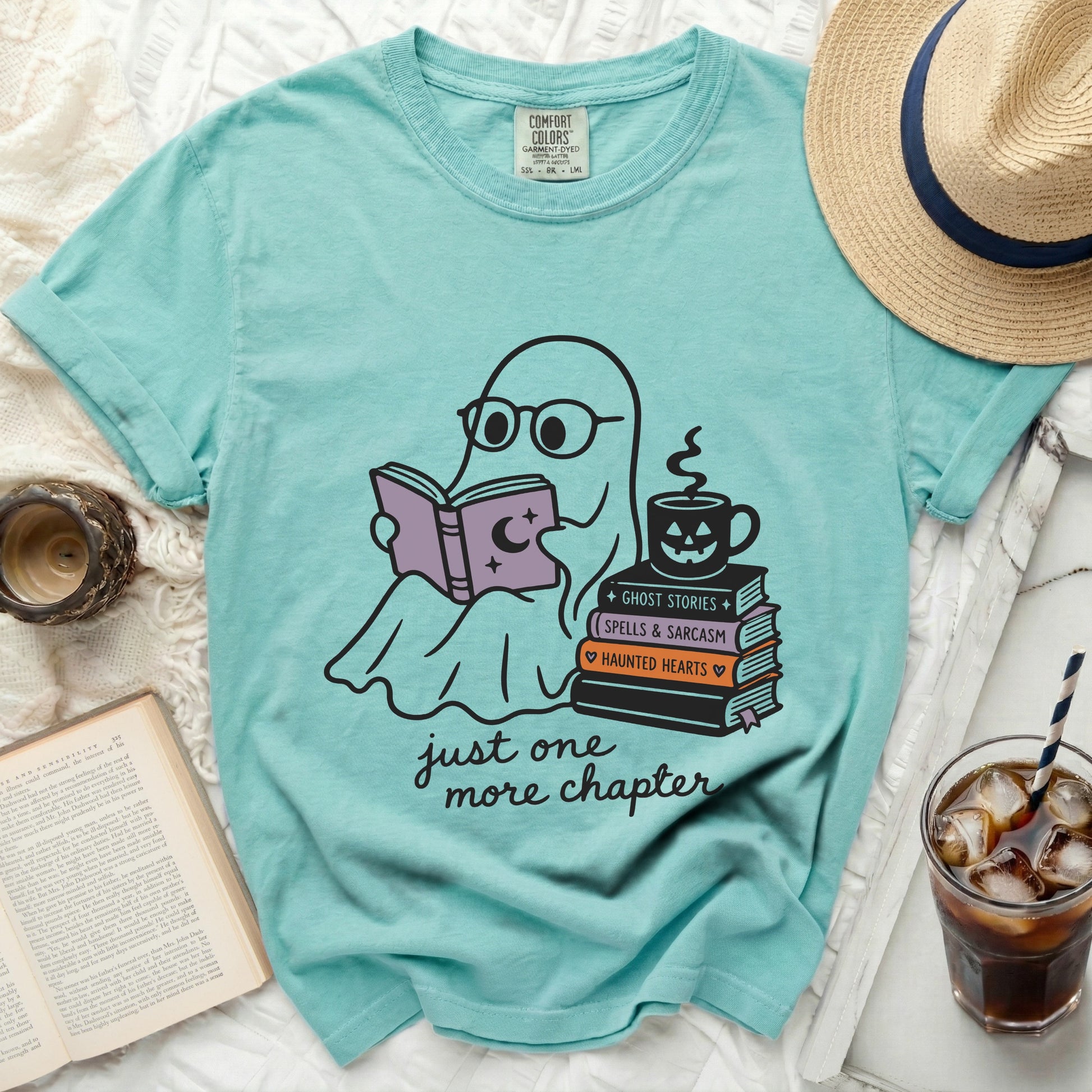 Teal T-shirt with graphic of ghost reading book, stacks of books, and coffee cup.