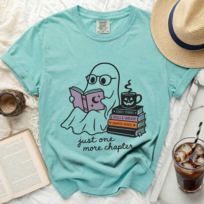 Teal T-shirt with graphic of ghost reading book, stacks of books, and coffee cup.