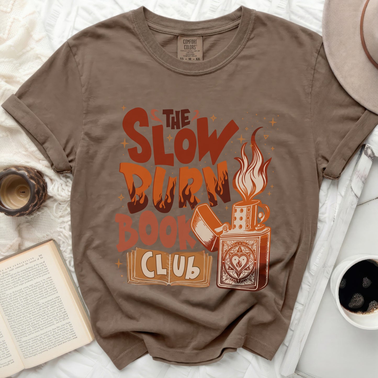 Brown t-shirt with graphic design "The Slow Burn Book Club" and a lighter.