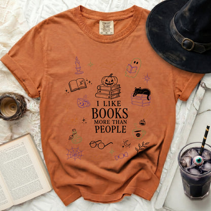 Orange t-shirt with Halloween book graphics and "I like books more than people" text.