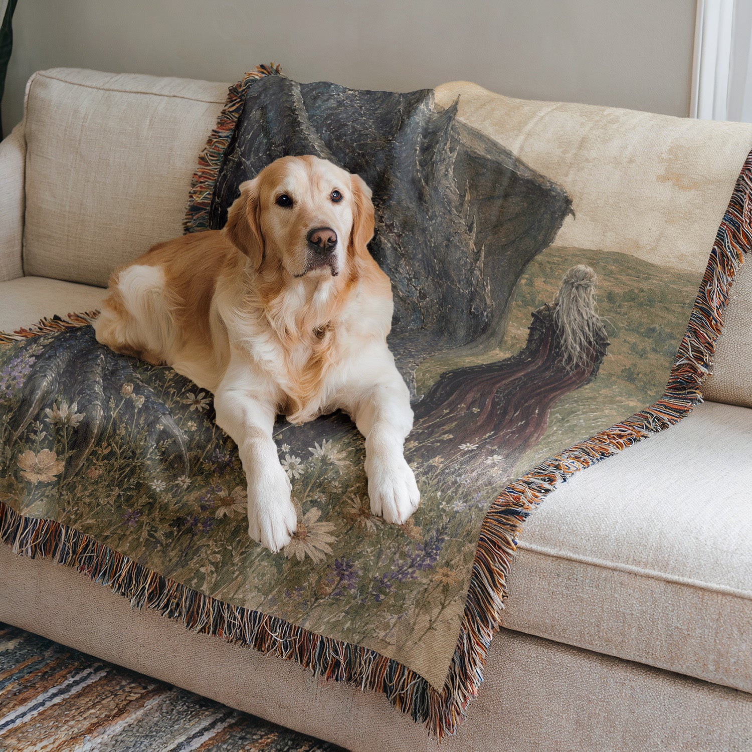 A golden retriever dog is lying on a couch with a colorful blanket featuring a landscape design.