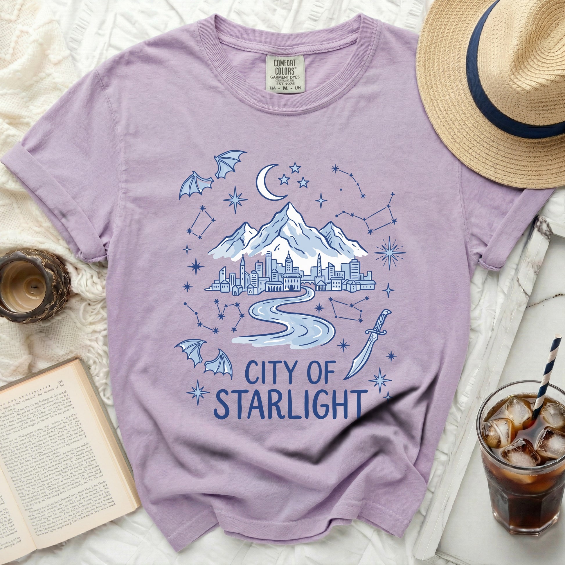 Purple t-shirt with "City of Starlight" text, cityscape, mountains, moon, stars, and bats.