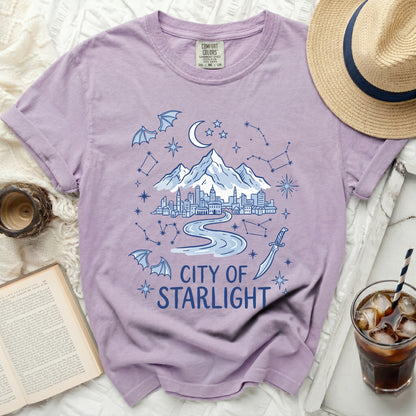 Purple t-shirt with "City of Starlight" text, cityscape, mountains, moon, stars, and bats.