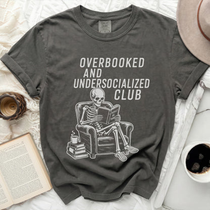 Overbooked and Undersocialized Club t-shirt with skeleton reading book.