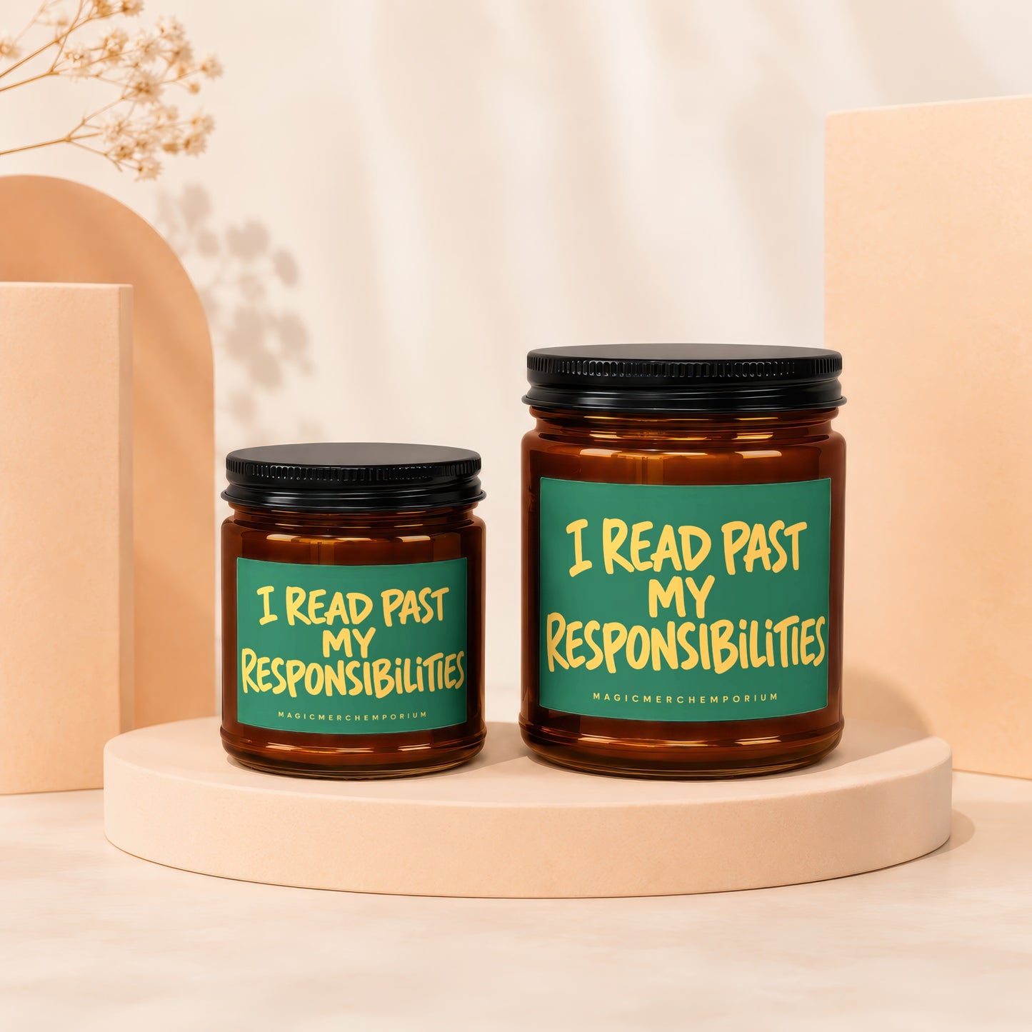 Two amber glass candles with black lids on beige pedestals, reading "I READ PAST MY RESPONSIBILITIES".