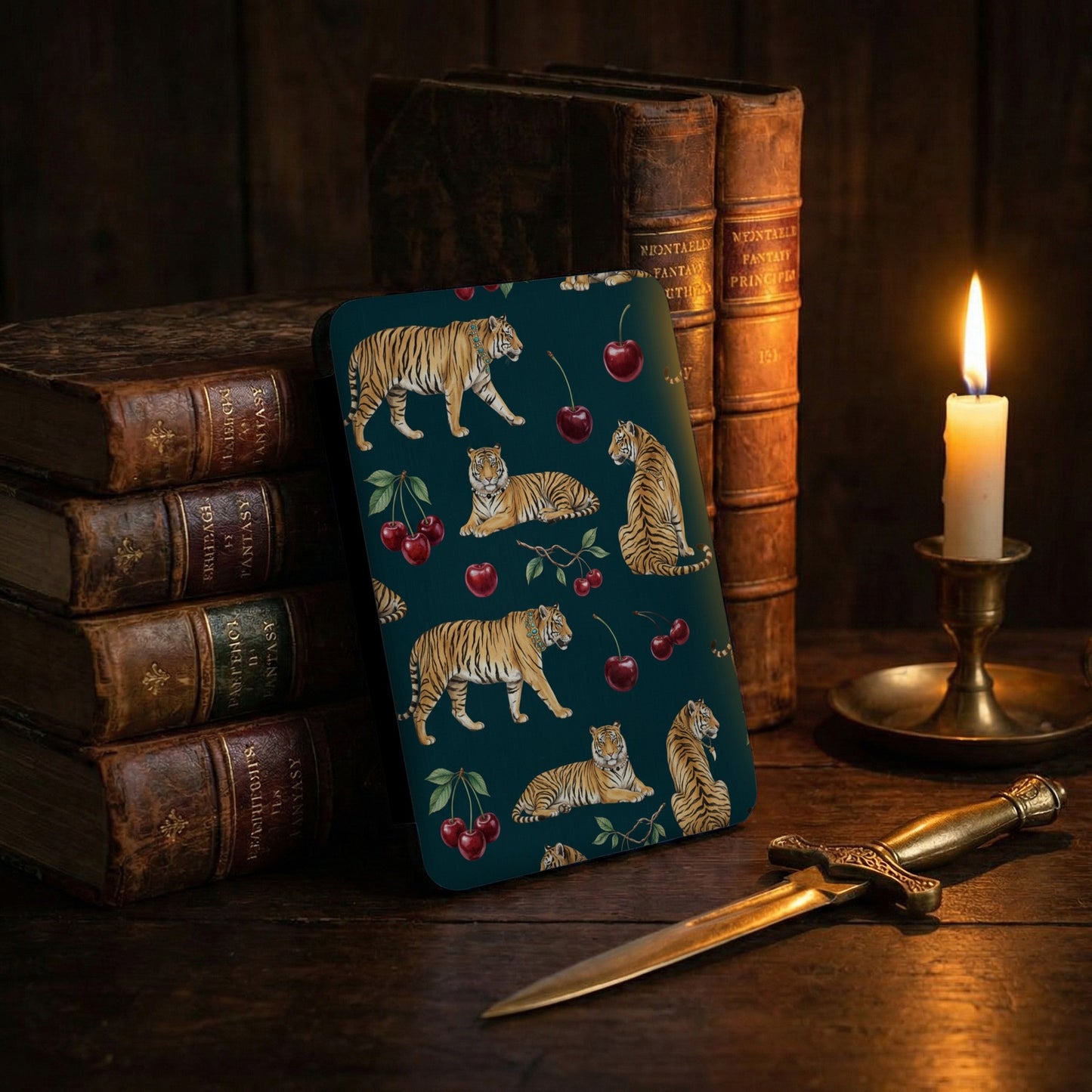 Device case with tiger and cherry pattern, antique books, and glowing candle.