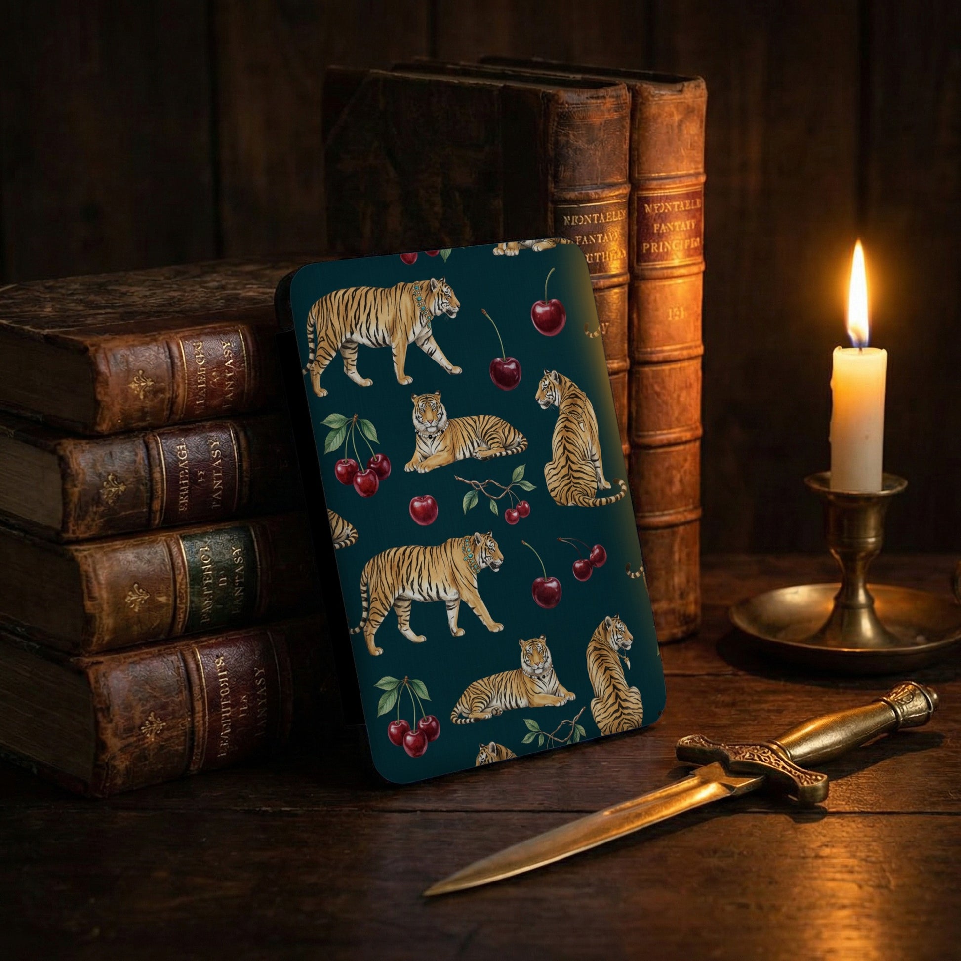 Device case with tiger and cherry pattern, antique books, and glowing candle.