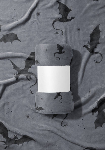 Rolled grey plush blanket featuring a dark grey dragon constellation print and a white band.
