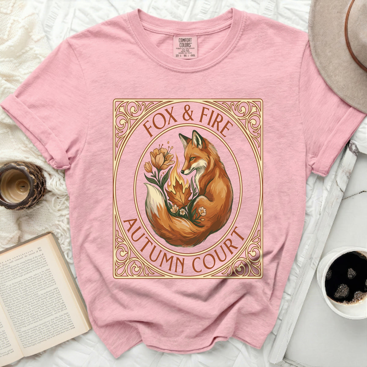 Pink t-shirt with a circular design of a fox, flowers, and flames, reading "Fox & Fire Autumn Court".