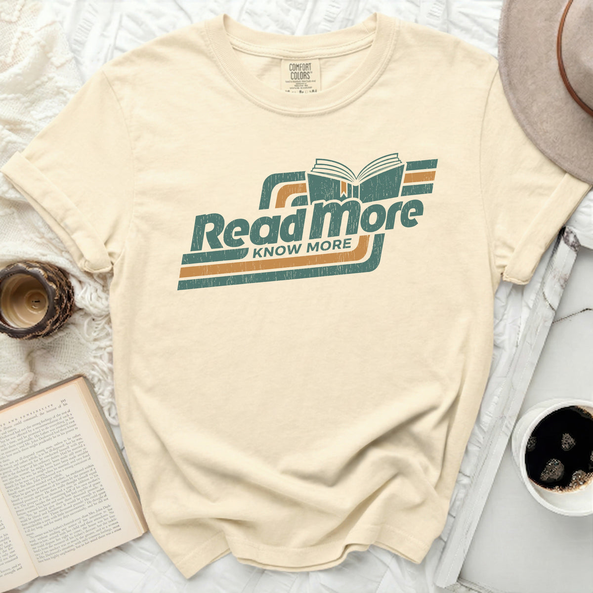 Cream t-shirt with teal and orange "Read More Know More" graphic.