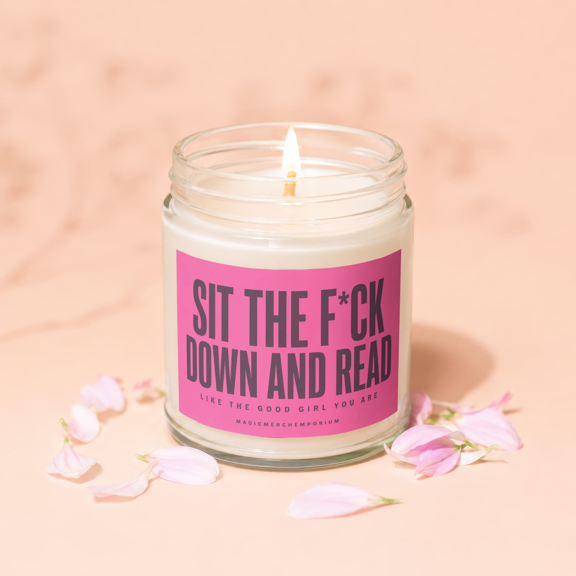 Jar candle with pink label reading "Sit the F*ck Down and Read Like the Good Girl You Are".
