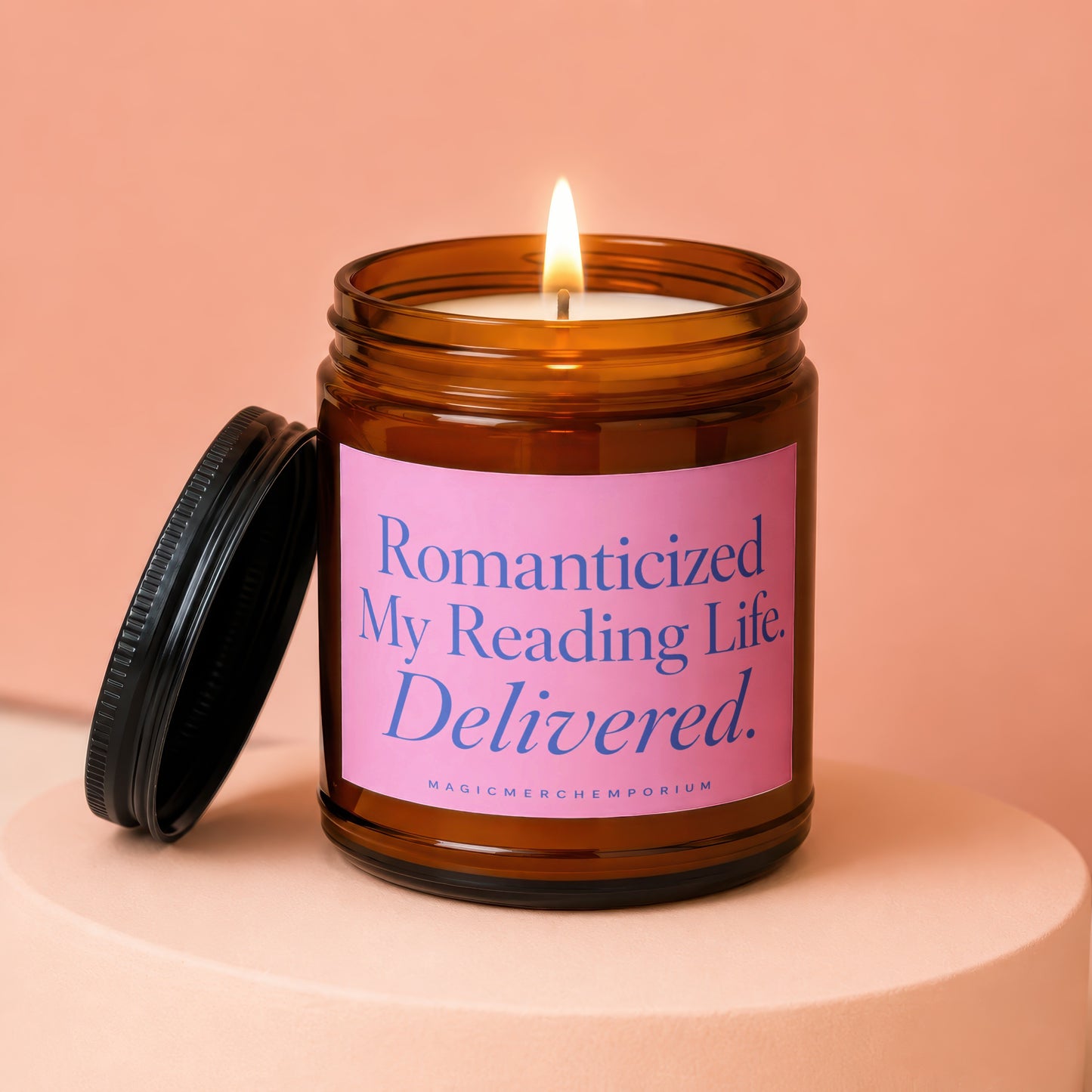 Amber jar candle with lit flame and pink label reading "Romanticized My Reading Life. Delivered."