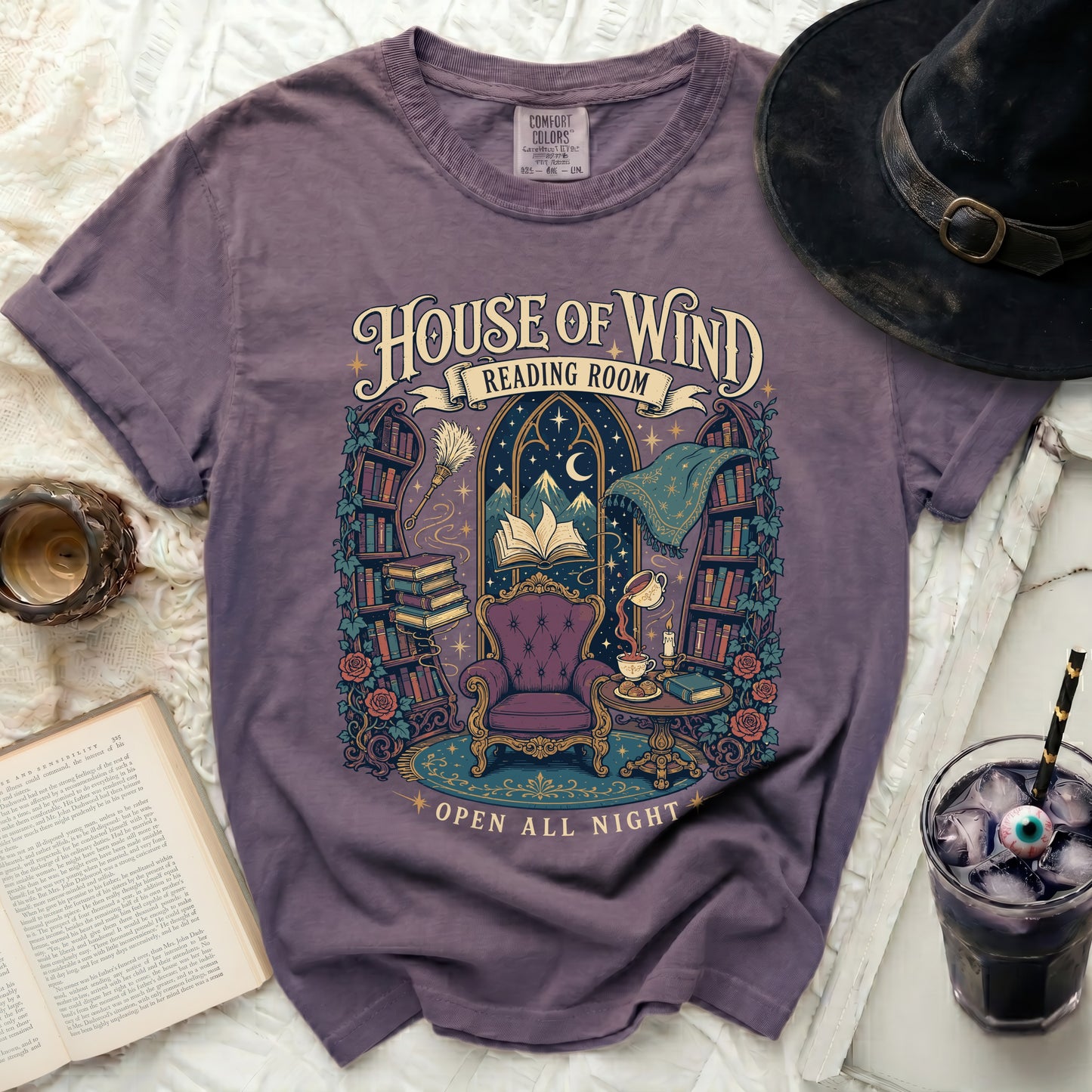 Purple t-shirt with "House of Wind Reading Room Open All Night" text and illustration.