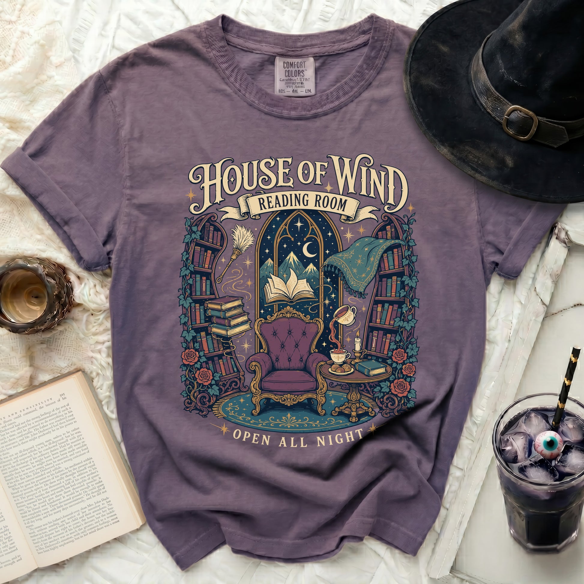 Purple t-shirt with "House of Wind Reading Room Open All Night" text and illustration.