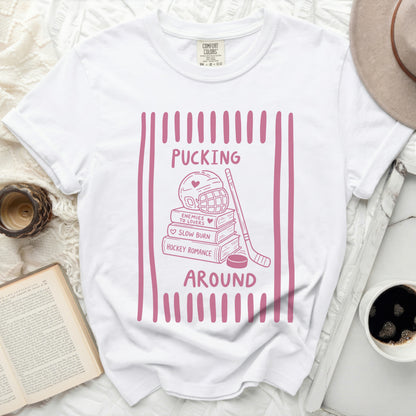 White t-shirt with pink hockey and book graphic reading "Pucking Around."