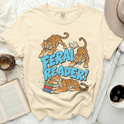 Cream t-shirt with three tigers and text "FERAL READER!" and a stack of books.