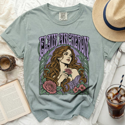 Light green t-shirt with "ELAINE ARCHERON" text and floral art of a woman holding a rose.