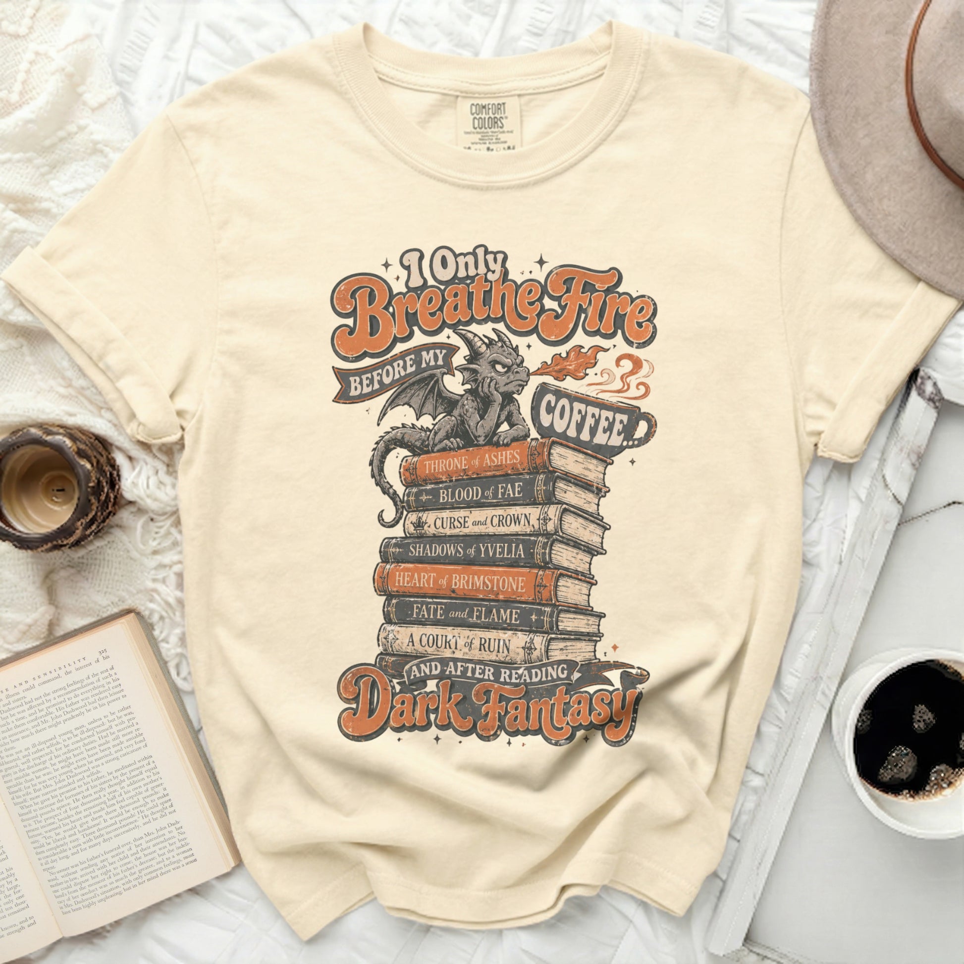 T-shirt with "I Only Breathe Fire Before My Coffee" and Dark Fantasy book titles.