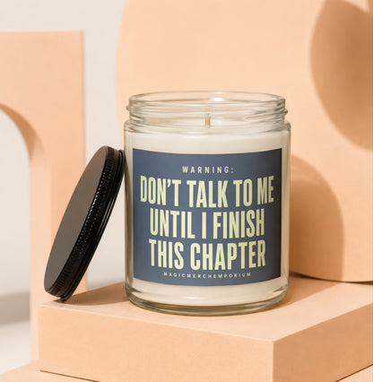Glass candle with dark label reading "WARNING: DON'T TALK TO ME UNTIL I FINISH THIS CHAPTER".