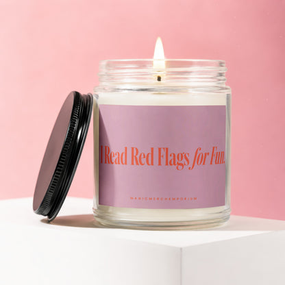 Glass jar candle with lit wick and black lid, reading "I Read Red Flags for Fun."
