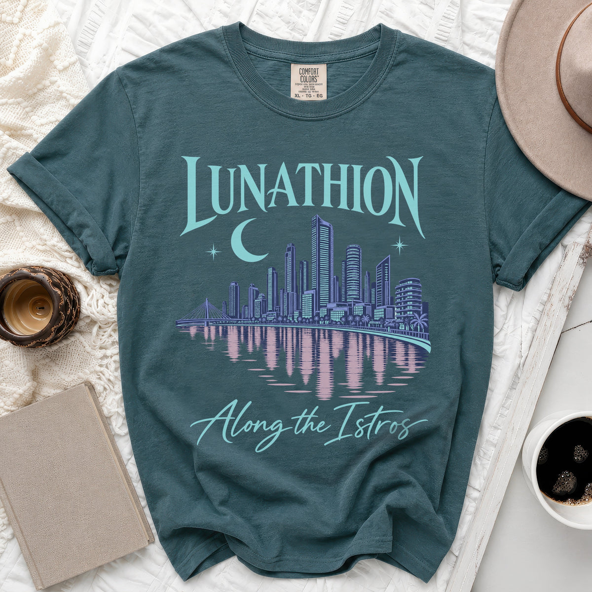 Teal t-shirt with "LUNATHION Along the Istros" text and a city skyline.