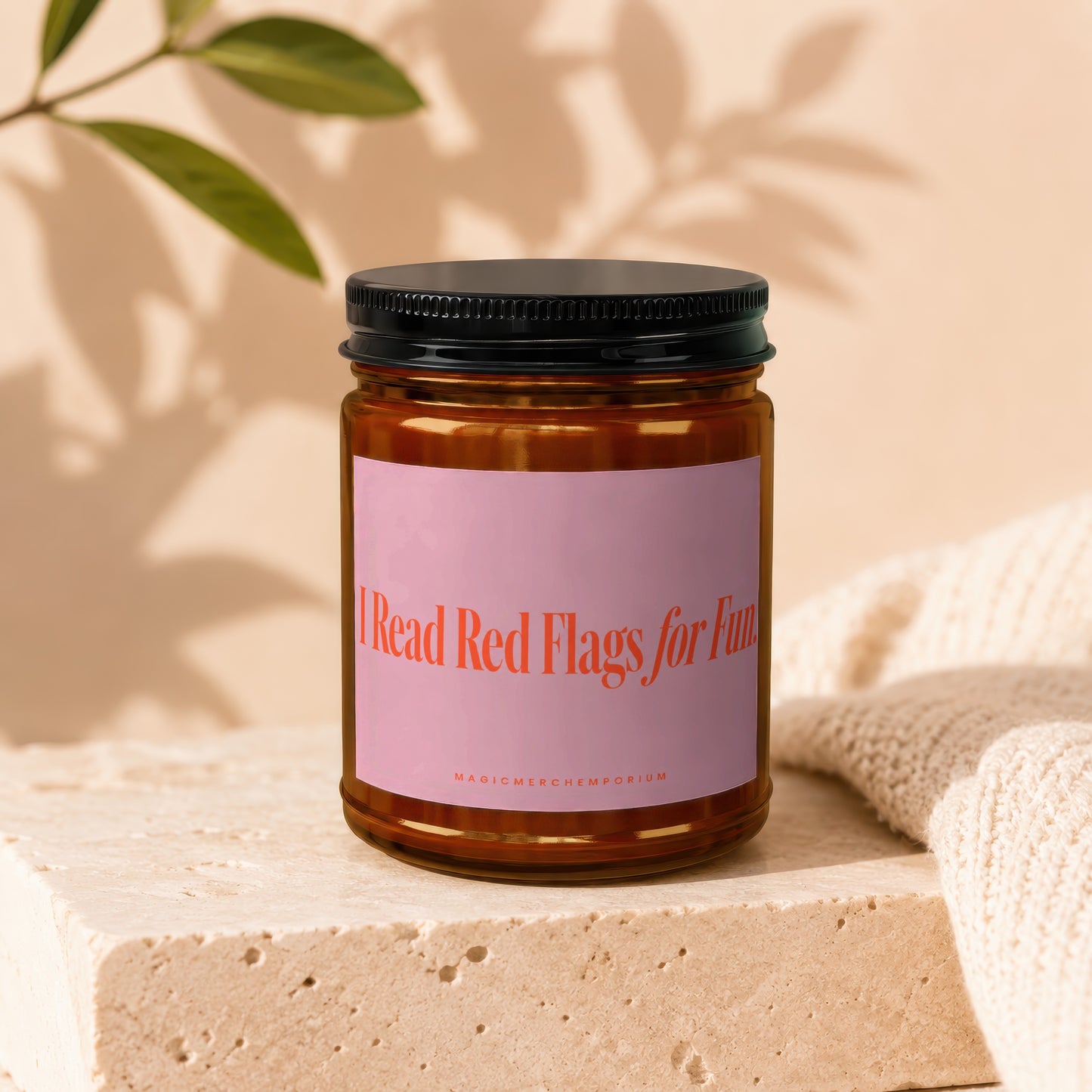 Amber glass candle with pink label reading "I Read Red Flags for Fun".
