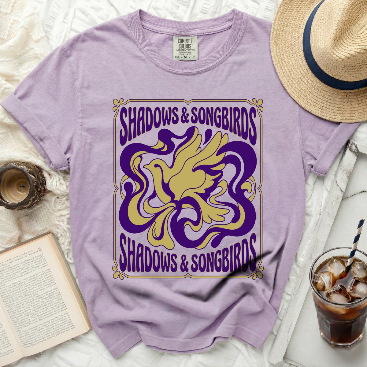 Purple t-shirt with yellow and purple "Shadows & Songbirds" graphic.