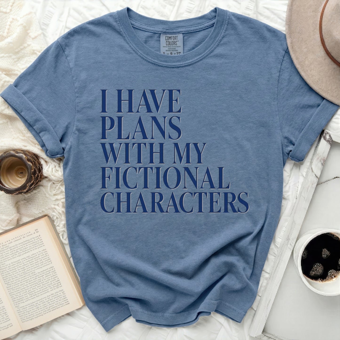 Blue t-shirt with "I HAVE PLANS WITH MY FICTIONAL CHARACTERS" text.