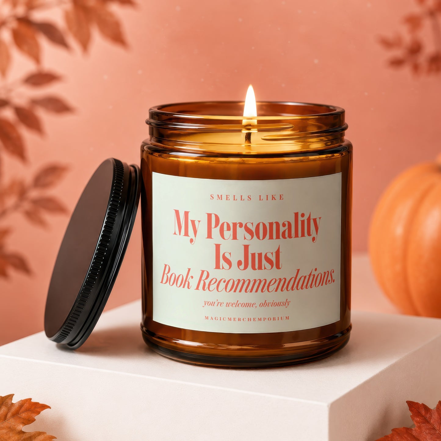 Lit amber glass candle with lid off, reading "My Personality Is Just Book Recommendations."