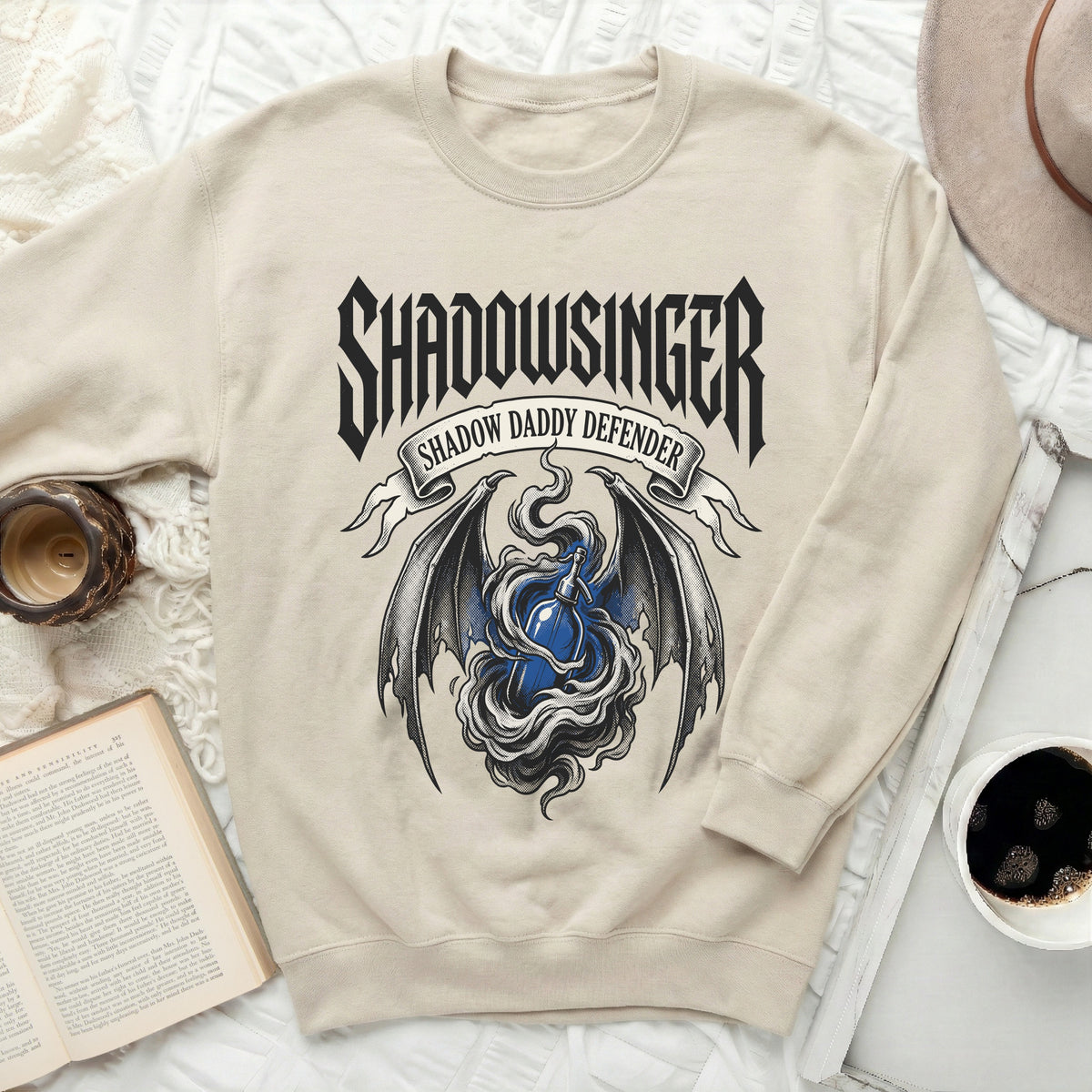 Cream sweatshirt with "SHADOWSINGER SHADOW DADDY DEFENDER" text and bat wings.