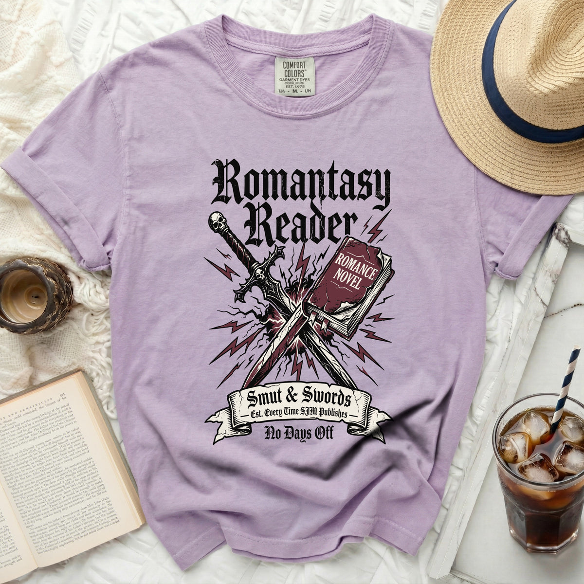 Purple t-shirt with "Romantasy Reader" graphic and sword over book.