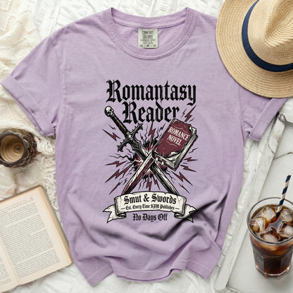 Purple t-shirt with "Romantasy Reader" graphic and sword over book.