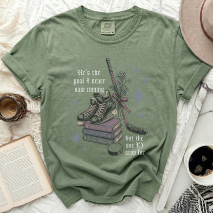 Green t-shirt with hockey stick, books, and quote "He's the goal I never saw coming."