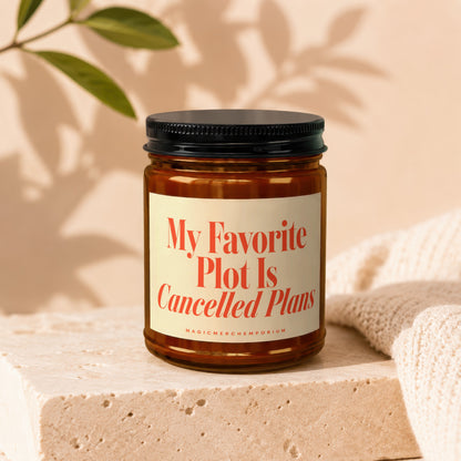 Candle with text "My Favorite Plot Is Cancelled Plans" on front label.