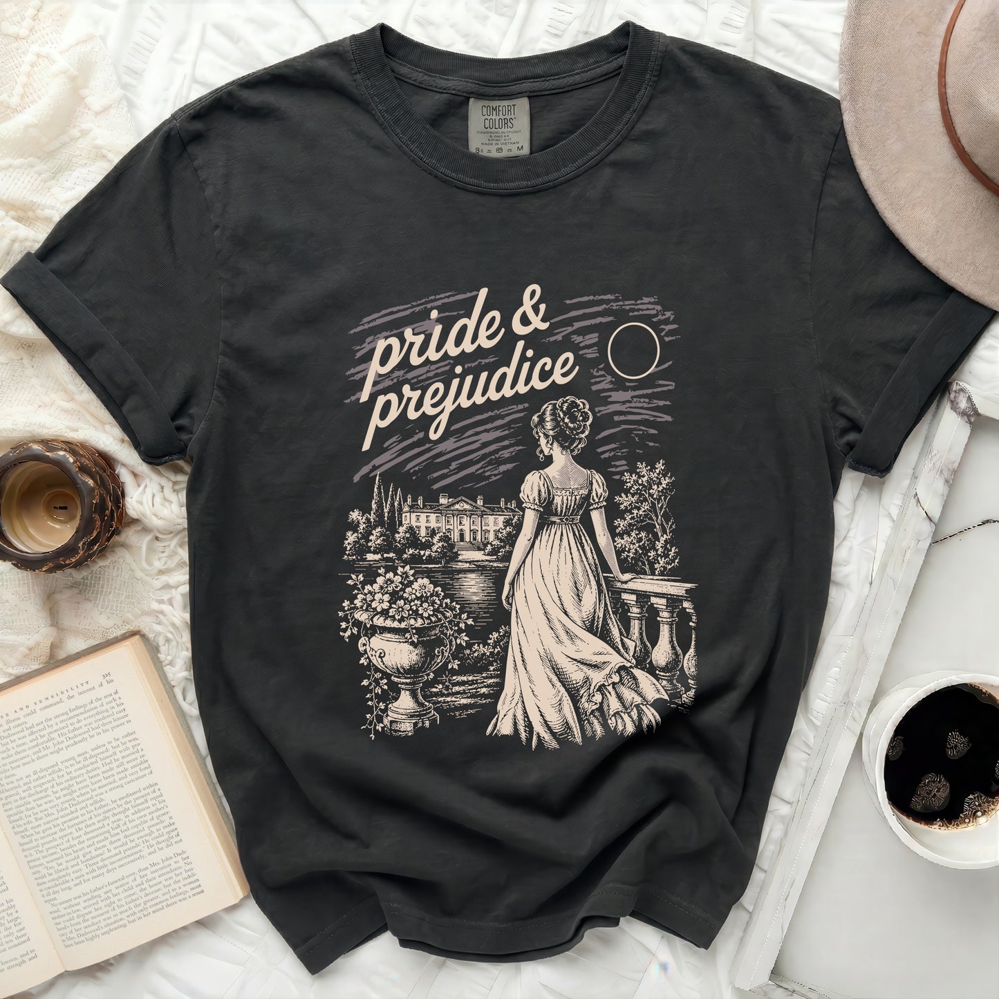 Dark t-shirt with "Pride & Prejudice" graphic of a woman at an estate.